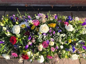 Medium coffin top in garden flowers and mixed foliage